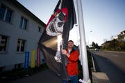 Alan Germann, Präsident des Häggenschwiler Schulrats, posiert mit einer Totenkopf-Flagge vor dem Oberstufenschulhaus Rietwies. (Bild: Urs Jaudas, 28. März 2011)