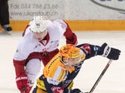 Zugs Topskorer Lino Martschini (vorne) hält den Puck vom Lausanner Joel Vermin fern (Bild: KEYSTONE/URS FLUEELER)