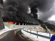Aus dem Schallbergtunnel oberhalb von Ried-Brig dringen nach einem Carbrand Flammen und Rauch. (Bild: Kantonspolizei Wallis)