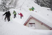 Die Menschen trotzen am Montag in Göschenen dem vielen Schnee. (Bild: KEYSTONE/Urs Flüeler)