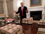 Pizza, Hamburger und Pommes anstelle feiner Häppchen: Wegen der Haushaltssperre hat US-Präsident Donald Trump ein Hochschul-Football-Team im Weissen Haus mit Fastfood bewirtet. (Bild: Chris Kleponis / EPA, Washington, 14. Januar 2019)