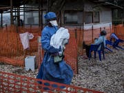 Eingesundheitsmitarbeiter bringt ein vier Tage altes Baby, das wahrscheinlich an Ebola erkrankt ist, in ein Behandlungszentrum. (Bild: KEYSTONE/AP Medecins Sans Frontieres/JOHN WESSELS)