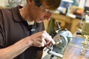 An einer Drehbank für Metall dreht Scarpatetti einen Pfeiler aus Messing.