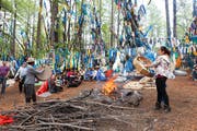 Schamanensitzung im Wald: Helfer wärmen die Trommeln am Feuer an.