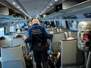 Mitarbeiter der Grenzwache kontrollieren in einem Zug Passagiere. (Bild: KEYSTONE/TI-PRESS/GABRIELE PUTZU)