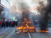 Brennendes Kartenhaus an der unbewilligten Anti-WEF-Kundgebung am Samstag in Berns Innenstadt. (Bild: Keystone/PETER KLAUNZER)