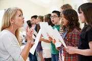 Eine Lehrerin singt mit Kindern: In Ostschweizer Schulen ertönt die Landeshymne nur selten. (Bild: Getty)