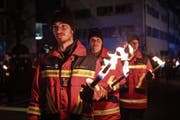 Die Mitglieder der Freiwilligen Feuerwehr der Stadt Zug beim traditionellen Fackelumzug. (Bild: Patrick Hürlimann (Zug, 26. Januar 2019))
