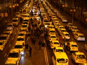 Aus Protest gegen Fahrdienste wie Uber blockierten Taxifahrer in Madrid mit ihren Fahrzeugen zentrale Strassen - nun hat die Polizei die Strassen geräumt. (Bild: KEYSTONE/AP/ANDREA COMAS)