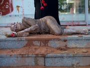 Rotbraun beschmierte Menschen legten sich vor das Vale-Hauptquartier im Stadtteil Botafogo und hinterliessen ihre Handabdrücke an einer Glaswand. (Bild: KEYSTONE/AP/SILVIA IZQUIERDO)