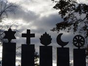 Symbole der fünf Weltreligionen auf verlorenem Posten? In der Schweiz lebt mittlerweile jeder Vierte ohne Religion. (Bild: Keystone/URS FLUEELER)