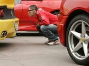 Mit Liebe für's Detail: Ein Fan begutachtet den legendären Sportwagen aus Maranello. (Bild: KEYSTONE/AP/WALLY SANTANA)