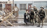 So sah der Alltag 1972 aus: Britische Truppen helfen einer Zivilistin um eine Barrikade herum. (Bild: AP)