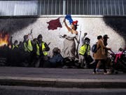 Mit seinem Wandgemälde, das Eugène Delacroix' Werk «Die Freiheit führt das Volk» nachempfunden ist, solidarisiert sich der Künstler Pascal Boyart in Paris mit der Bewegung der Gelbwesten. (Bild: Keystone/EPA/ETIENNE LAURENT)