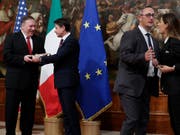 Sorge um den Export von Wein, Käse und anderem mehr: US-Aussenminister Mike Pompeo (links) hat von einer Journalistin gerade ein Paket Parmesan erhalten. Die Journalistin (rechts) wird weggeführt. (Bild: KEYSTONE/AP/ANDREW MEDICHINI)