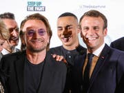 Der französische Präsident Macron (rechts) mit dem irischen U2-Sänger Bono (2. von links) in Lyon. (Bild: KEYSTONE/AP AFP Pool/LUDOVIC MARIN)