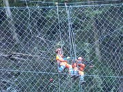 Arbeiter stellen das Steinschlagschutznetz am Axen in Stand. (Bild: Bundesamt für Strassen Astra)