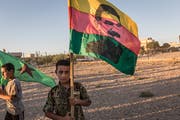 Ein kurdischer Junge demonstriert mit einer Fahne des Kurdenführers Abdullah Öcalan für mehr Selbstbestimmung. (Bild: Imago Images)