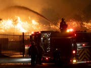 Retten, was noch zu retten ist - Feuerwehrleute in Sylmar nördlich von Los Angeles. (Bild: KEYSTONE/AP The Orange County Register/DAVID CRANE)