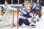 Zugs Grégory Hofmann (gelber Helm) trifft zum 4:2 gegen ZSC-Torhüter Lukas Flüeler. Bild: Ennio Lanza/Keystone (Zürich, 12. Oktober 2019)