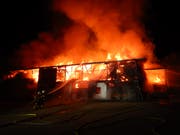 Feuerwehrleute kämpfen gegen die lodernden Flammen. (Bild: Kapo)