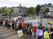 Aktivisten der Umweltbewegung Extinction Rebellion haben am Samstag in Amsterdam eine Brücke blockiert. (Bild: KEYSTONE/EPA ANP/EVERT ELZINGA)