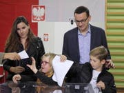 Polens Ministerpräsident Mateusz Morawiecki mit Familie am Sonntag bei der Stimmabgabe - die Regierungspartei Recht und Gerechtigkeit (PiS) von Morawiecki errang bei der Parlamentswahl ersten Prognosen zufolge einen klaren Sieg. (Bild: Keystone/EPA PAP/PAWEL SUPERNAK)
