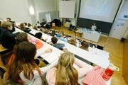 Kinder sitzen im Hörsaal der PH Zug und hören den Ausführungen der Désirée Berhane-Gygax vom Verein Therapiehunde Schweiz zu. (Bild: Stefan Kaiser, Zug, 22. November 2017)