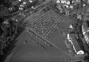 St.Gallen in der Nachkriegszeit: 1953 wird die Kreuzbleiche für einen Grossanlass als Parkplatz verwendet. Noch stehen am oberen Bildrand zwischen Militärkantine und Reithalle die Kaserne und das Zeughausmagazin. Rechts oben auf der Kreuzbleiche zwischen Turnhalle und Hotel St.Leonhard (heute «Il Castello») fehlt die Sporthalle. (Bild: Stadtarchiv der Ortsbürgergemeinde St.Gallen/Sammlung Foto Gross)