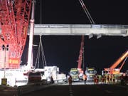 Ein riesiger Kran stand in der Nacht auf Dienstag im Waadtland im Einsatz. In Bursins ersetzten 60 Bauarbeiter eine alte Autobahnbrücke über die A1 zwischen Lausanne und Genf. (Bild: Keystone/LAURENT GILLIERON)