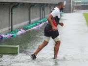 Der japanische Rugby-Spieler Michael Leitch trainiert in Tokio auf einem von Taifun «Hagibis» überfluteten Spielfeld. (Bild: KEYSTONE/AP Kyodo News)