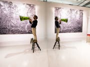 Ein Mann übt mit Flüstertüte im Ehrengast-Pavillon auf der Buchmesse für eine bevorstehende Performance. Der Raum wurde mit Spiegelflächen optisch erweitert und wirkt licht, kühl, minimalistisch. (Bild: Keystone/DPA/ANDREAS ARNOLD)