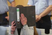 Sarah O. versteckt ihr Gesicht hinter einem Aktenordner. (Bild: David Young/DPA)