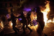 Polizisten zwischen brennenden Barikaden. (Bild: AP, Barcelona, 16. Oktober 2019)