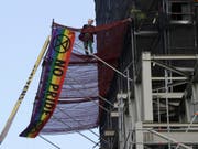 Ein als Premier Boris Johnson toupiertes Mitglied der Bewegung Extinction Rebellion entrollt am Glockenturm Big Ben des britischen Parlaments in London ein Banner. (Bild: KEYSTONE/AP/KIRSTY WIGGLESWORTH)