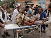 Sanitäter kümmern sich um einen der Dutzenden Verletzten nach dem Bombenanschlag auf eine Moschee in der ostafghanischen Provinz Nangarhar. (Bild: KEYSTONE/AP/WALI SABAWOON)