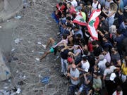 Anti-Regierungs-Demonstranten versuchen in Beirut Stacheldraht zu überwinden und zum Regierungspalast vorzudringen. (Bild: KEYSTONE/AP/HASSAN AMMAR)