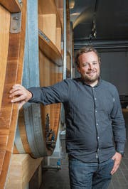 Christoph Möhl in der Mosterei vor Fässern aus Eichenholz. (Bild: Urs Bucher)