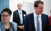 Nach getaner Arbeit tritt der Zuger Landschreiber Tobias Moser in den Hintergrund, während sich Nationalrat Thomas Aeschi (SVP, rechts) über seinen erneuten Wahlsieg freut. (Bild: Stefan Kaiser, Zug, 20. Oktober 2019)