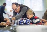 Besucher am Repair-Café flicken ein ferngesteuertes Auto. (Bild: Andrea Stalder)
