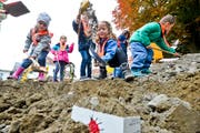 Die Kinder vergraben ihre selbst gestalteten Ziegelsteine in den vier Ecken der Baustelle. (Bild: Donato Caspari)