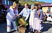 Die Wilden überreichen im Grossteil dem früheren Giswiler Jugendseelsorger und Festprediger Beat Zellweger (Bildmitte) einen Alpkäse. (Bild: Romano Cuonz, Giswil, 26. Oktober 2019)