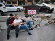 Mit Sitzstreiks, Barrikaden und quergestellten Fahrzeugen blickieren Demonstranten im Libanon wichtige Verkehrsadern. (Bild: KEYSTONE/AP/HUSSEIN MALLA)