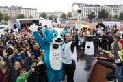 Die Schweizer Para-Athletin Celine van Till präsentiert in Lausanne zusammen mit Maskotchen "Yodli" das olympische Feuer für die Winter-Jugendspiele. (Bild: Salvatore Di Nolfi/Keystone, 28. Oktober 2019)