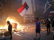In Chile gab es am Montag (Ortszeit) erneut vielerorts Ausschreitungen - in der Hauptstadt Santiago geriet sogar ein Einkaufszentrum in Brand. (Bild: KEYSTONE/AP/RODRIGO ABD)