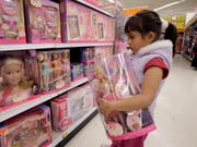 Kundin in einem US-Geschäft vor Regalen mit Puppen des «Barbie»-Herstellers Mattel. (Bild: KEYSTONE/AP/NICK UT)