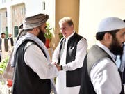 Händeschütteln und Umarmungen für die Taliban: Pakistans Aussenminister Shah Mehmood Qureshi (Mitte) beim Begrüssen der Delegation in Islamabad. (Bild: KEYSTONE/AP Pakistan Foreign Office)
