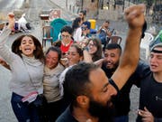 Libanesische Anti-Regierungsprotestler feiern in der Hauptstadt Beirut den Rücktritt von Ministerpräsident Saad Hariri. (Bild: KEYSTONE/AP/BILAL HUSSEIN)