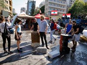 Demonstranten im Libanon haben am Mittwoch mit dem Abbau von Barrikaden begonnen. In Beirut gaben sie zentrale Strassen wieder frei. (Bild: KEYSTONE/AP/BILAL HUSSEIN)