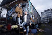 Sie wollen den alten Eisenbahnwagen vor der Industrie 45 in ein besonderes Café umbauen: Fabio Fölmli (links) und Kai Imholz. Die Dritte im Bunde ist Laura Hürlimann. Sie fehlt auf dem Bild. (Bild: Werner Schelbert, Zug, 4. Januar 2018)